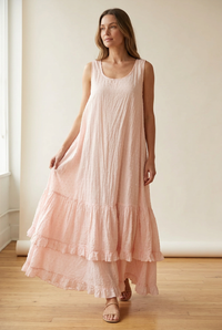 On-model visualization of the blush pink dress showing its flowing drape